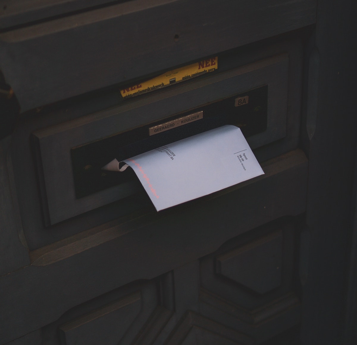 a letter peeking out of a postbox